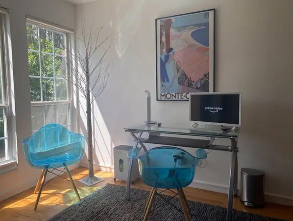 Work in comfort with a glass desk and computer, two chairs, and a large window.