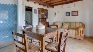 Un comedor con mesa y sillas de madera, un armario y un sofá.