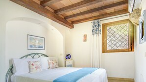 Un dormitorio con una cama, una ventana con diseño de celosía y techo de madera.