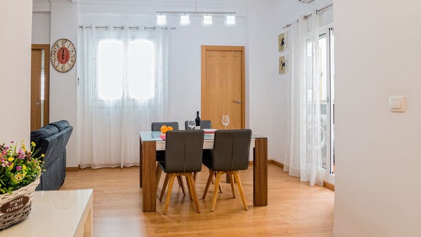Een eethoek met een tafel, stoelen en een houten deur.