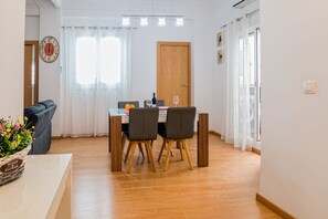 Un comedor con una mesa, sillas y una puerta de madera.
