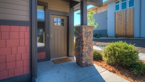 A house with a front door, a stone pillar, and a small garden.