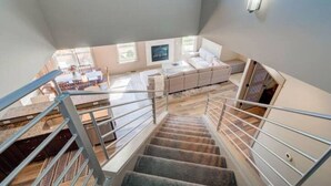 A spacious living area with a staircase leading to an upper floor.