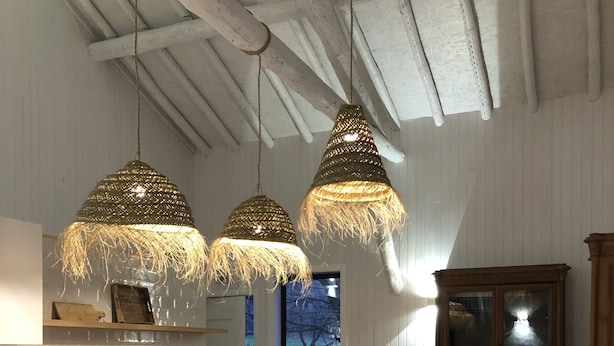A spacious kitchen with wooden cabinets, a dining table, and hanging pendant lights. - Geres National Park barn (Arcos Valdevez)