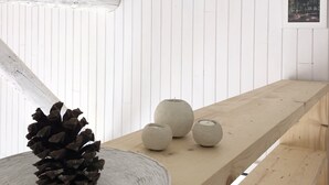 A wooden table with a pine cone centerpiece, three spherical objects, and a framed picture on the wall. - Geres National Park barn (Arcos Valdevez)