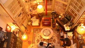 A cozy, well-lit room with a large circular rug, a piano, and various decorative items.