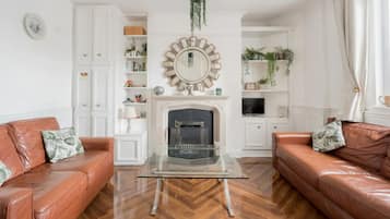 Casa básica, varias camas | Área de sala de estar | Televisión y chimenea