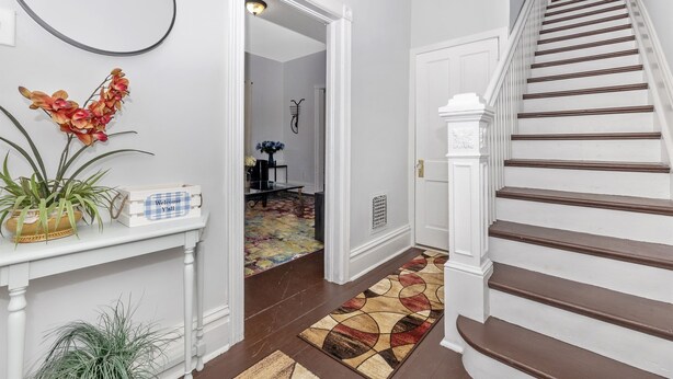 A staircase with white railings and brown steps leading to a room.