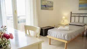 Une chambre à coucher avec un lit, une table de chevet, une lampe et une fenêtre avec des rideaux.