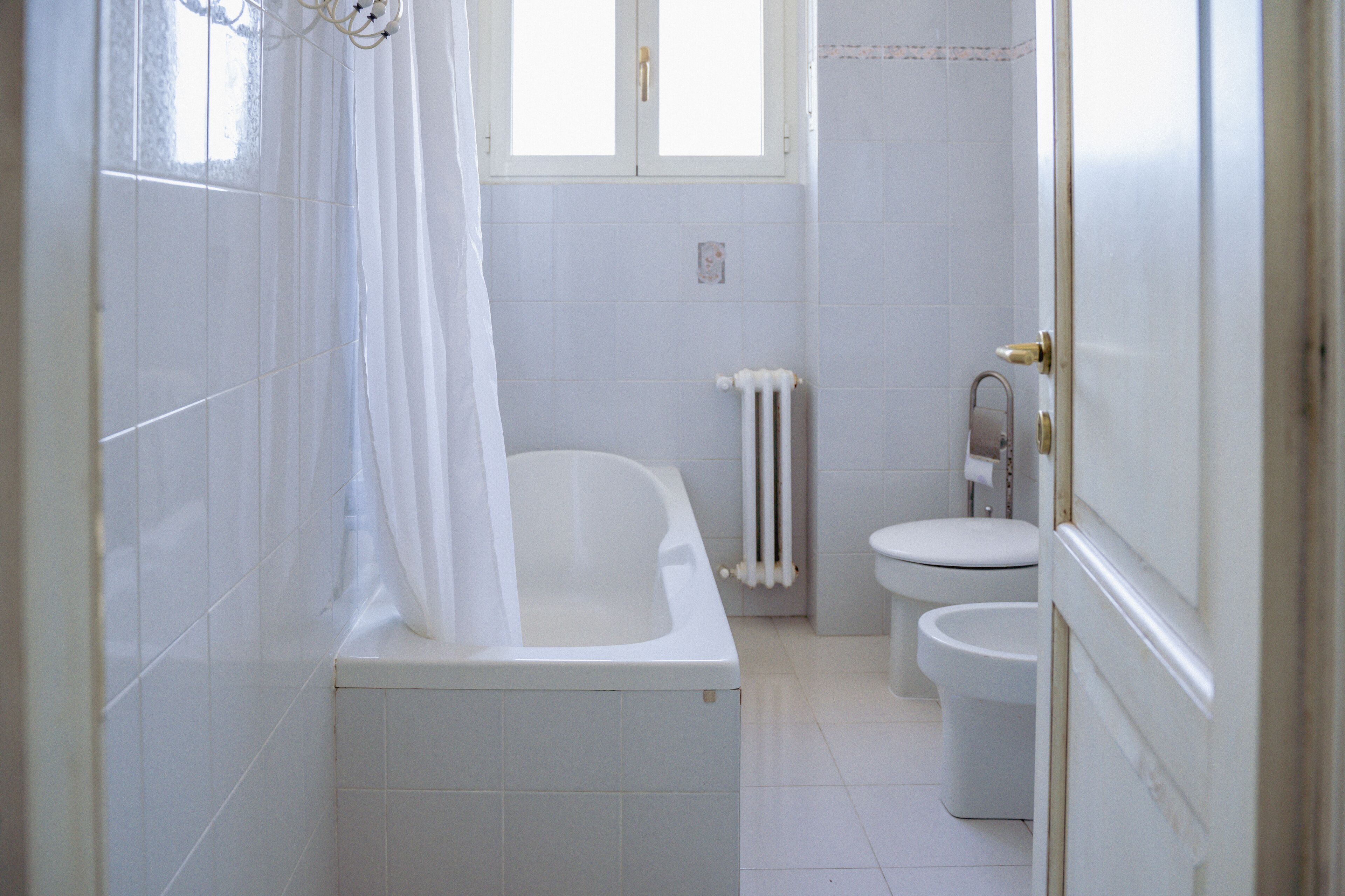 Ein Badezimmer mit Badewanne, Toilette und Handtuchheizkörper.
