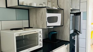 Una cocina moderna con microondas integrado, tostadora y refrigerador.