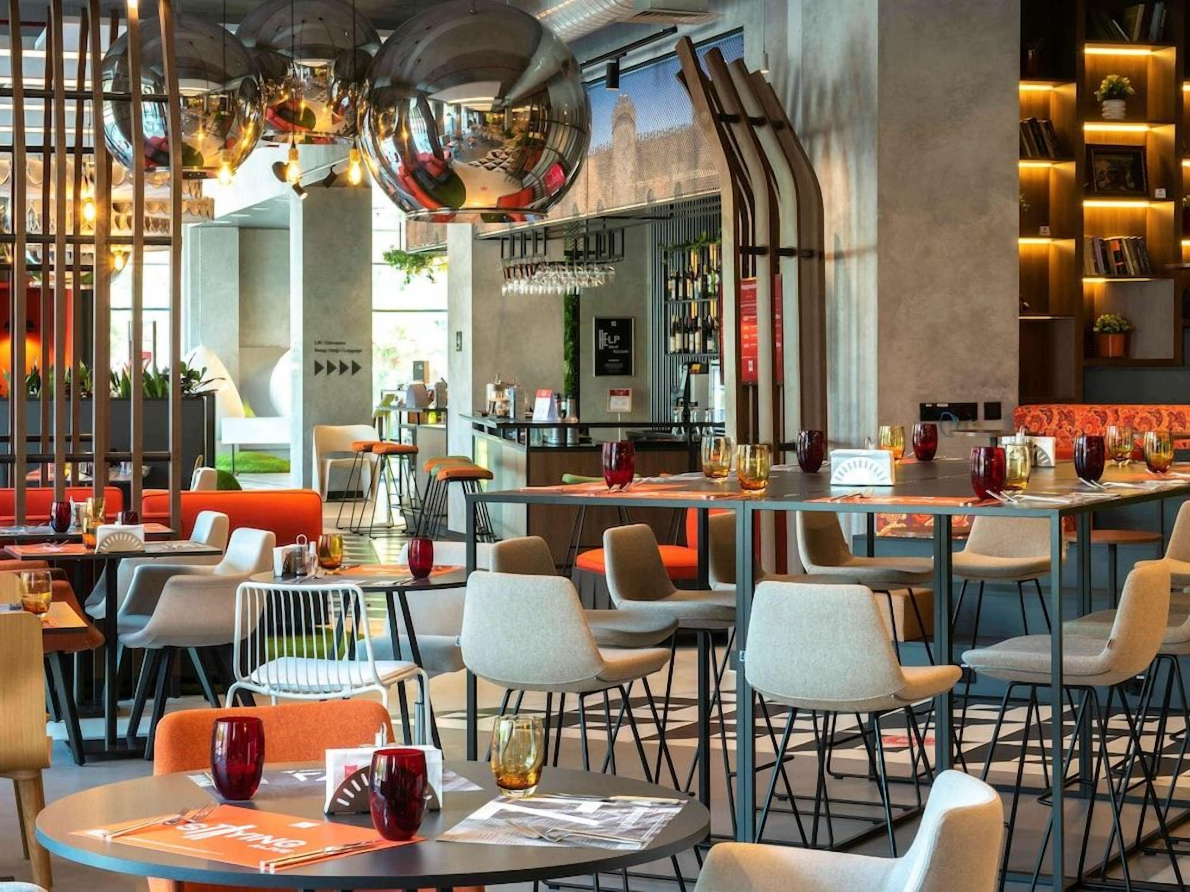 Een modern restaurantinterieur met ronde tafels, een bar en een open bar.