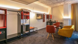 A modern hotel room with a bunk bed, a desk, a chair, and a wardrobe. - Ibis Baku City Hotel (Baku)