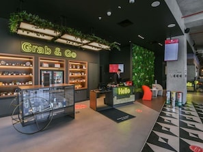 Un interior moderno con un mostrador 'Grab & Go', una recepción y una vitrina de cristal.