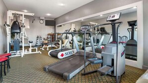 A gym with treadmills, weight machines, and a red exercise bench. - Quality Inn Brookhaven, MS (Brookhaven)