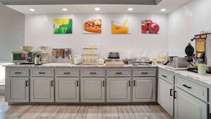 A breakfast bar with a waffle maker, coffee machine, and a waffle station. - Quality Inn Brookhaven, MS (Brookhaven)