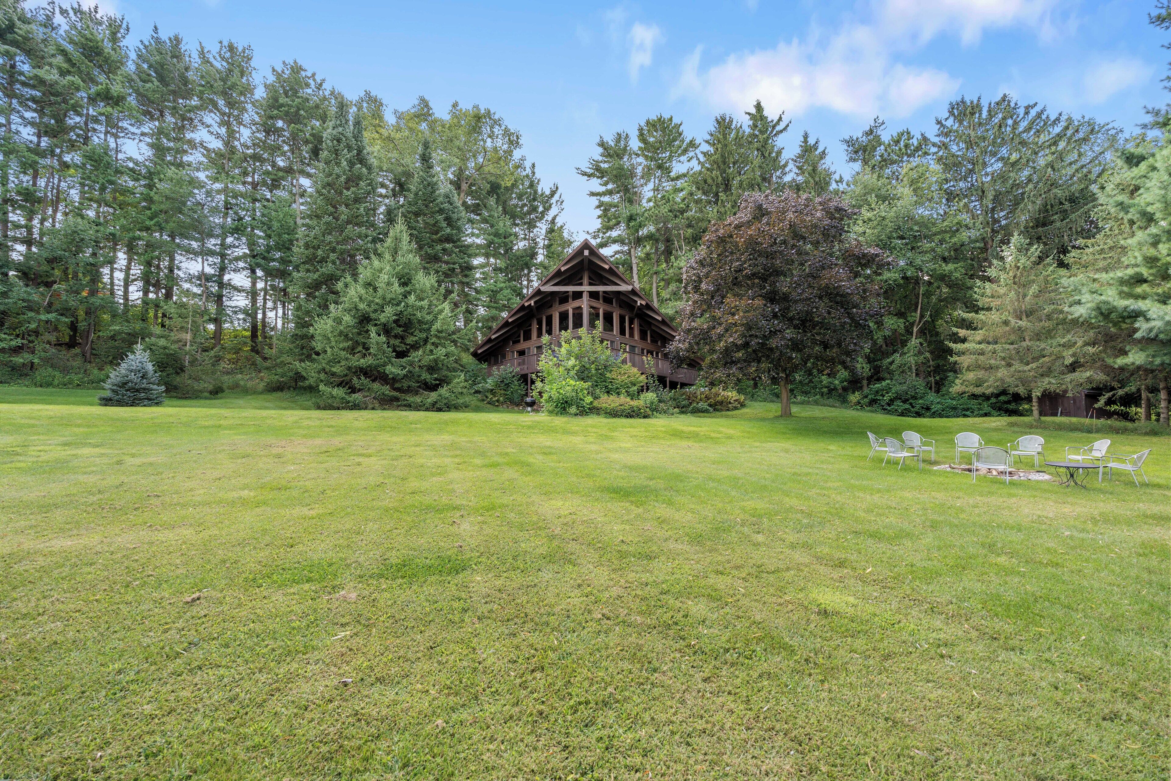 A lodge with a wooden structure surrounded by a grassy area and trees.
