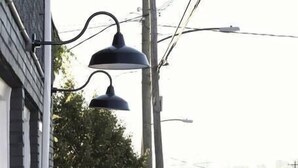 A building with a visible entrance, a street view with cars, and overhead power lines. - Micro Motel 2 Bed! Su (Nashville)