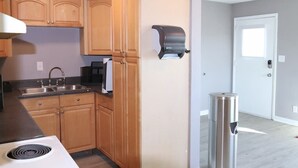 Una cocina con armarios de madera, un lavamanos de acero inoxidable y una estufa blanca.