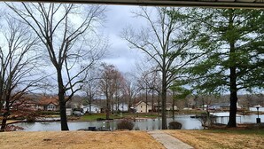 A view of a residential area with a pond, houses, and trees. - Lake Front, Family fun- Sleeps 8, Newly modern remodeled 3bed/2bath private dock (Creal Springs)