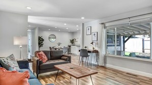 A modern living room with a sofa, coffee table, and dining area. - Escape to Wine Country with Friends & Family (Santa Rosa)