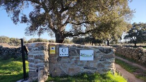 Un muro de piedra con un letrero de Rucanon Casas Rurales, número 2.