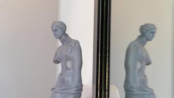 A statue of a woman in a reflective surface.