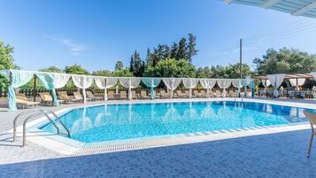 Piscine extérieure en saison, parasols, chaises longues