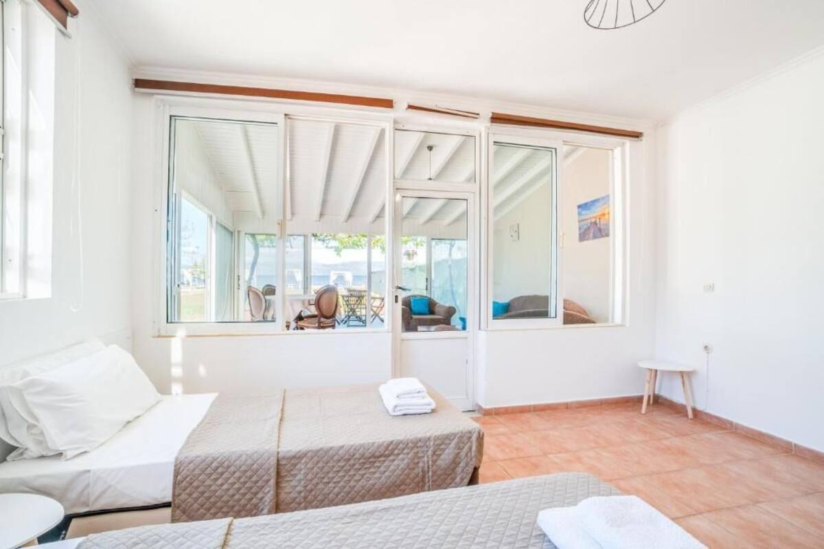 Una habitación con dos camas, ventanas amplias y vistas al exterior.