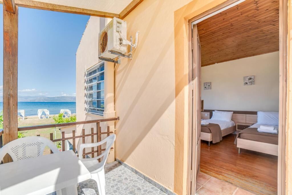 Un balcon avec vue sur la mer, un plafond en bois et une pièce comprenant deux lits et un canapé.