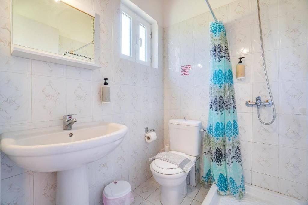 A bathroom with a sink, toilet, and shower.
