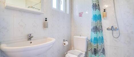 A bathroom with a sink, toilet, and shower.