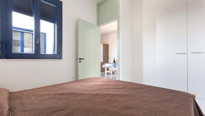 Une chambre à coucher avec un lit, une armoire et une fenêtre.