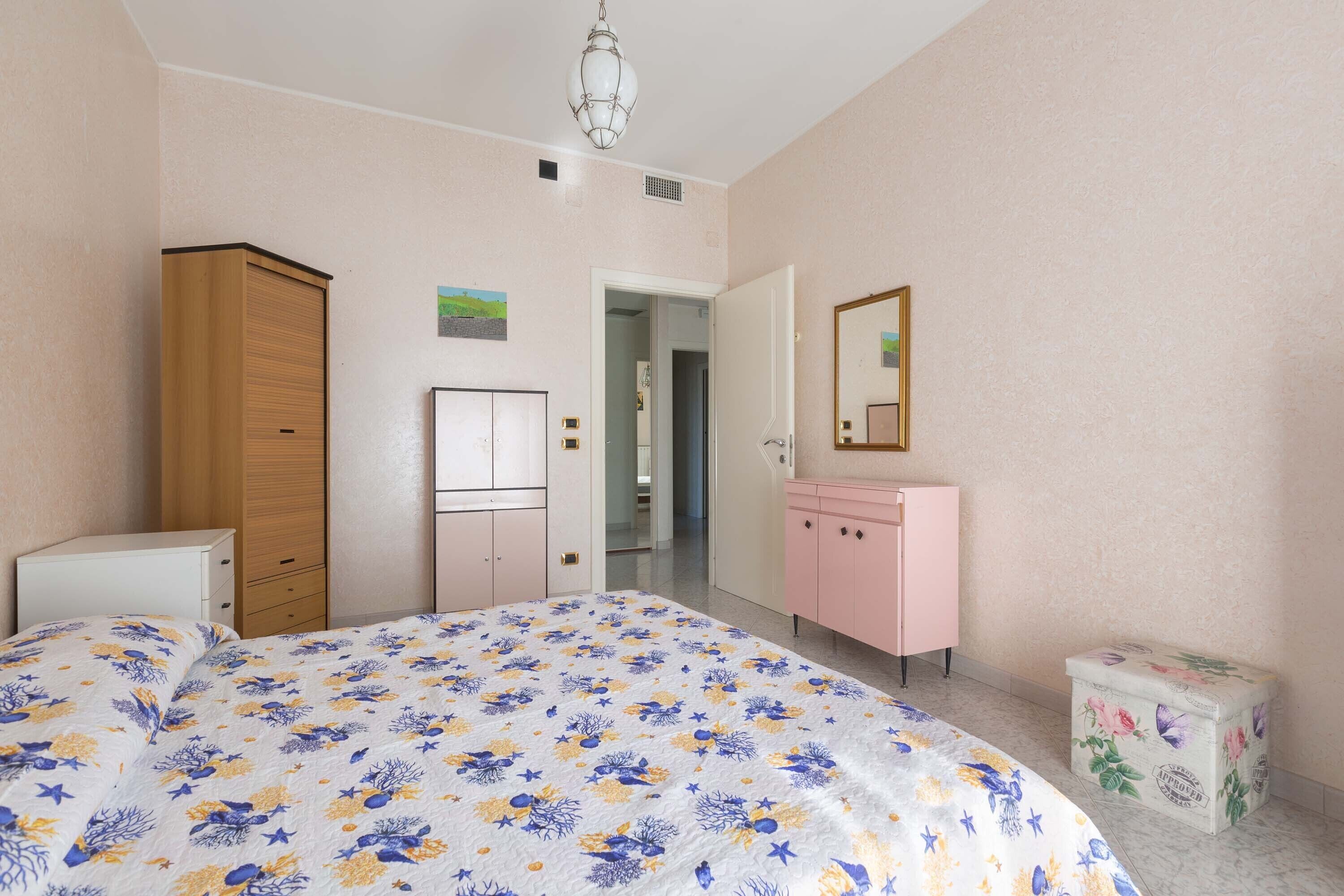 A bedroom with a bed, a wardrobe, a dresser, and a small cabinet.