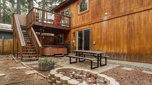 A wooden cabin with a deck, a fire pit, and a picnic table. - Pine Mountain Paradise 3 Bedroom Home by RedAwning (South Lake Tahoe)