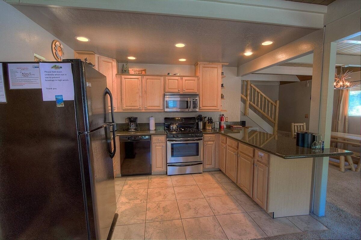 A kitchen with wooden cabinets, stainless steel appliances, and a breakfast bar.