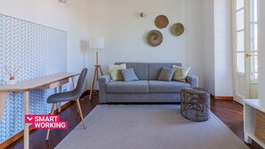 A modern living room with a grey sofa, a wooden coffee table, a standing lamp, and a patterned rug. - Green Rose by Wonderful Italy (Bellagio)