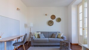 A modern living room with a grey sofa, a wooden coffee table, a standing lamp, and a patterned rug. - Green Rose by Wonderful Italy (Bellagio)