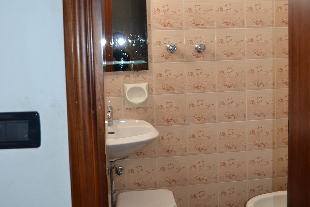 A bathroom with a toilet, sink, and shower.