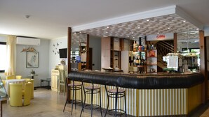 A bar area with a counter, stools, and a view of the kitchen in the background. - Hotel Rosy (Bellaria-Igea Marina)