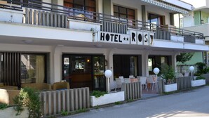 A hotel with a balcony, outdoor seating, and a sign that reads "HOTEL ROSY". - Hotel Rosy (Bellaria-Igea Marina)