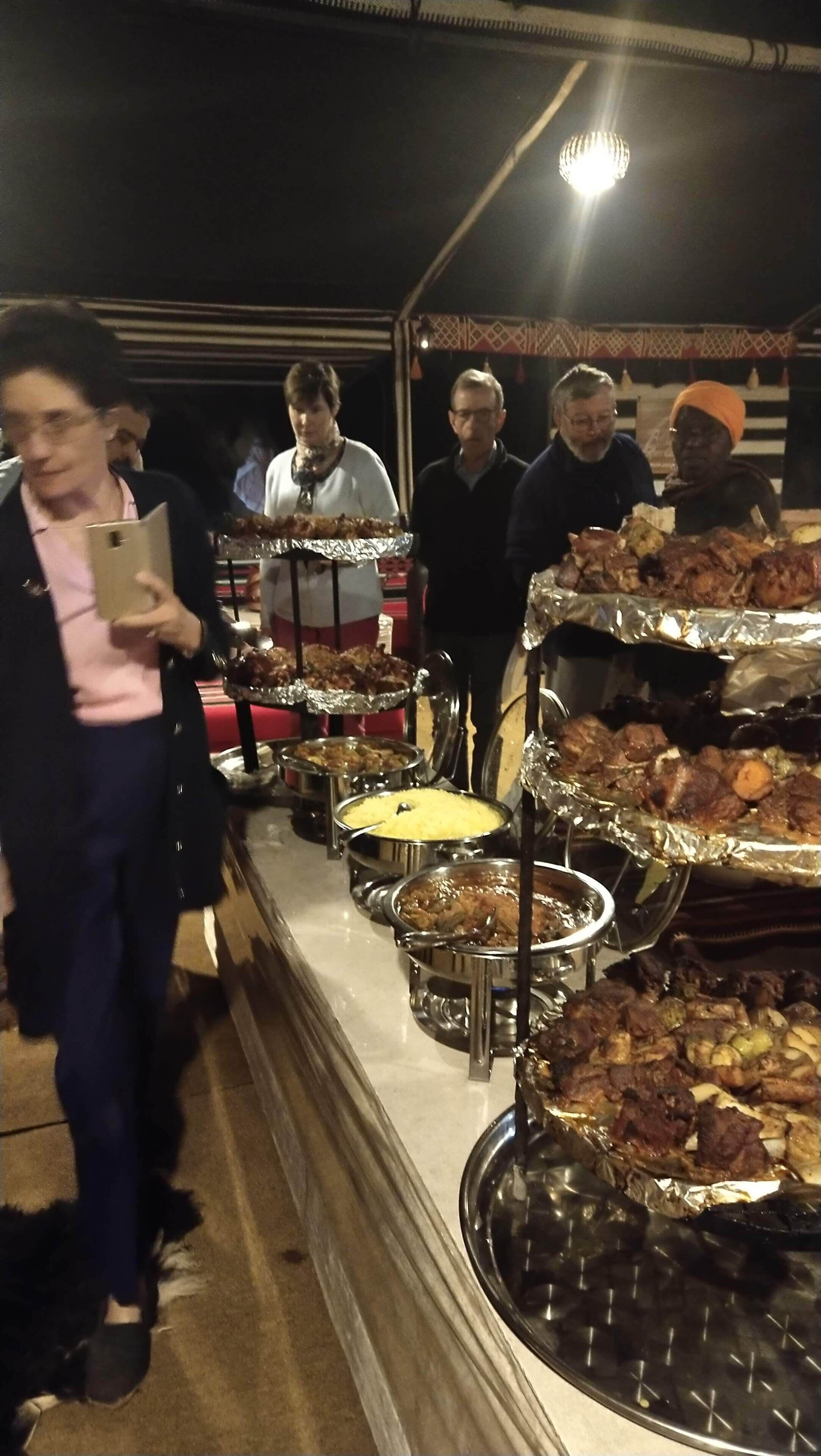A buffet with multiple food stations, including various meats and a casserole dish.