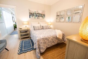 Une chambre à coucher avec un lit, des tables de chevet, une lampe et un tapis.