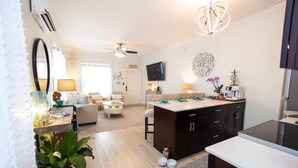 A modern kitchen with dark cabinets, a white countertop, and a ceiling fan. - The Sandy Beach House in Historic Key West (Key West)
