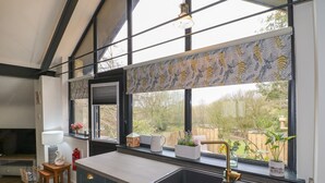 Une cuisine moderne dotée d’une grande fenêtre, de meubles en bois et d’un évier encastré.