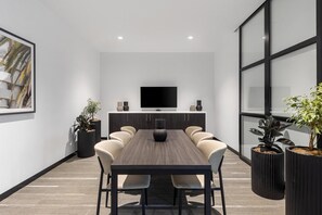 A modern conference room with a long table, chairs, a flat-screen TV, and potted plants. - Quest Geelong Central (Geelong)