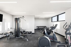 A modern gym with various exercise equipment, including a bench press, dumbbells, and cardio machines. - Quest Geelong Central (Geelong)