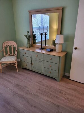 A room with a green dresser, a chair, and a door. - Villages home with Lanai & Golf Cart - Perfect location, golfers paradise (The Villages)