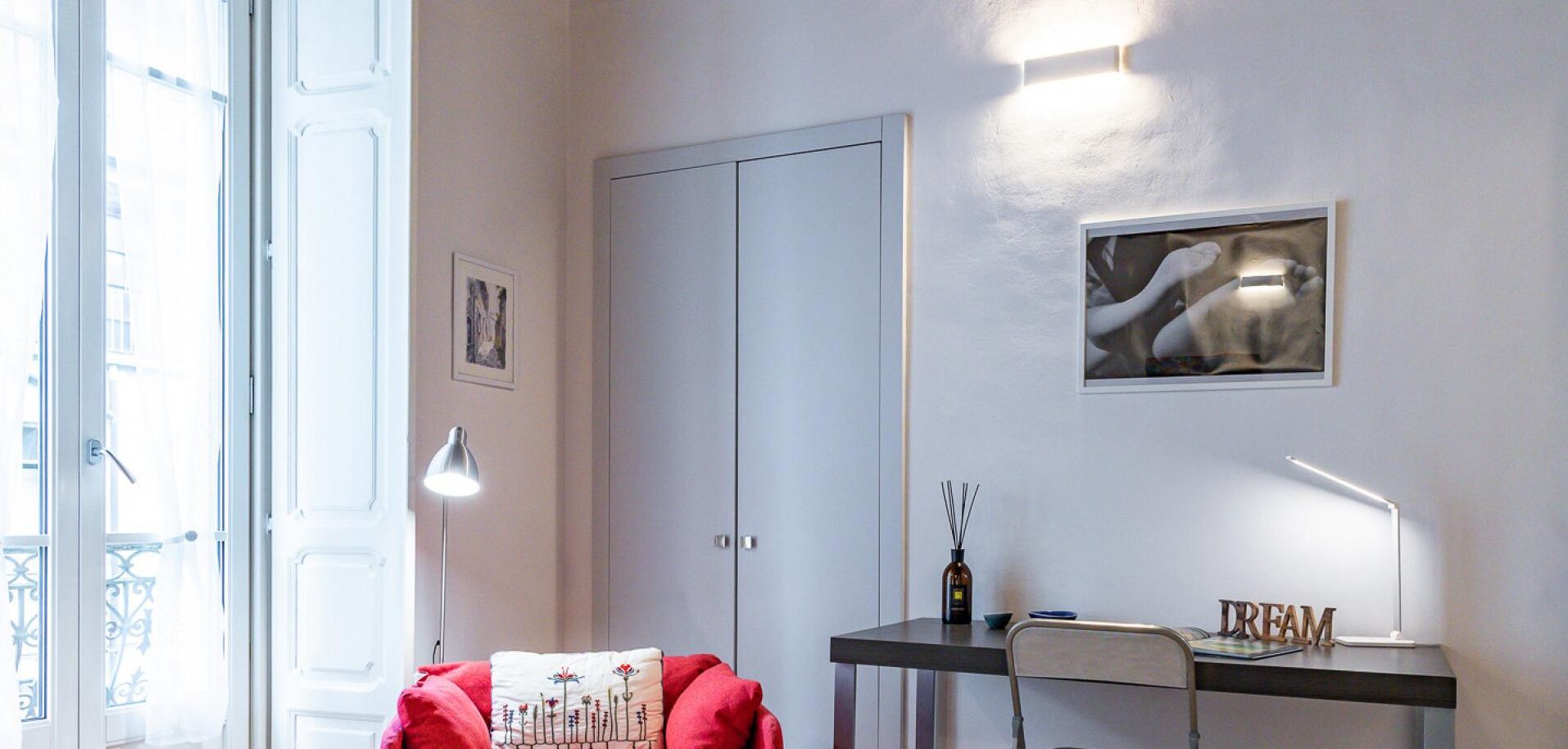 Une pièce comprenant un bureau, une chaise, une lampe et une porte.