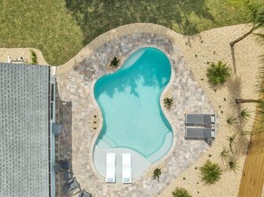 An aerial view of a swimming pool with a pebble border, two lounge chairs, and a small deck area. - The Blue Oasis - 3/2 POOL Home S Jax Beach (Jacksonville Beach)